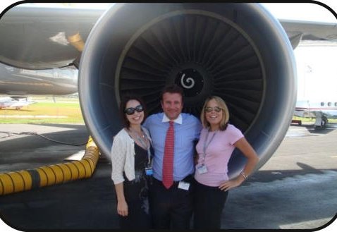 The team beside an airliner engine nacelle